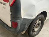 a white van with a red and black stripe parked in a garage