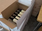 Des cartons de vin sont empilés les uns sur les autres dans une pièce