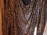un pull marron et noir avec un imprimé animalier, suspendu à un cintre