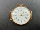 a small gold pocket watch with roman numerals on the face
