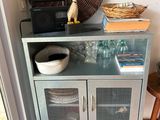 a small cabinet with baskets on top of it in a room