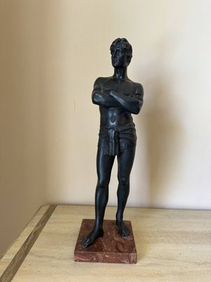 a statue of a man standing with his arms crossed