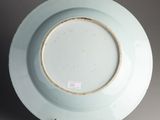 a white plate with a brown rim on a stand