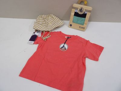 a red t - shirt and a hat on a table