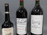 trois bouteilles de vin sont alignées sur une surface grise