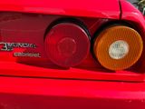 a close up of a red car with its tail lights on