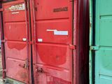 two red containers sitting next to each other on the side of the road