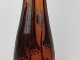 a brown and black vase sitting on a white surface