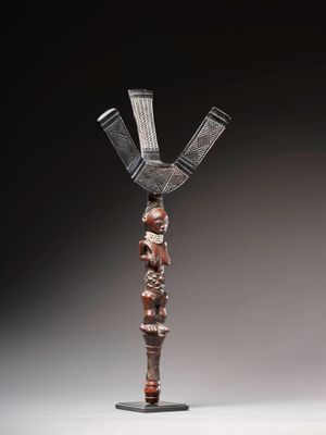 une sculpture en bois représentant une femme avec un panier sur la tête