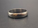 gros plan d'une bague en argent sur une surface noire