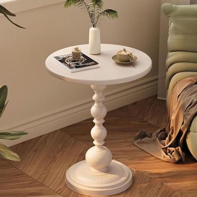 une table blanche sur laquelle se trouve une plante, dans un coin de la pièce