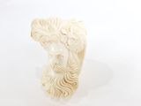 sculpture représentant une tête de femme sur fond blanc