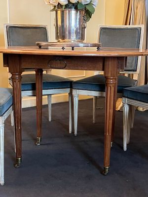 a table with chairs and a vase of flowers on top of it