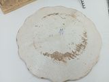 une assiette blanche sur laquelle est écrit quelque chose, posée sur une table à côté d'une paire de ciseaux