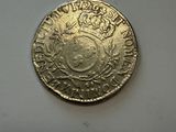 an old coin with a crown on it sitting on a table