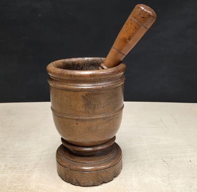 an old mortar with a wooden stick in it on top of a table