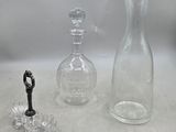 trois vases en verre et une bouteille posés sur une table