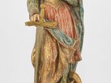 une vieille statue représentant une femme coiffée d'une couronne et tenant une épée