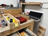 a workbench with tools and a laptop on it