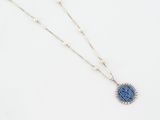 un collier avec un pendentif en pierre bleue monté sur une chaîne en argent