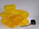 une chaise jaune fabriquée à partir de bouteilles en plastique, posée sur une surface blanche