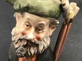 a figurine of a man with a hat and a cane