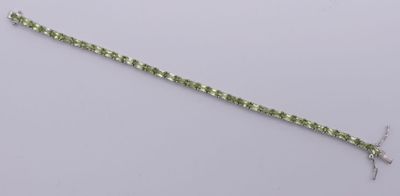 Bracelet ligne en argent,serti de péridots facettés.