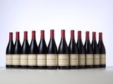 six bottles of red wine lined up in a row on a table