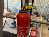 un extincteur rouge posé sur une étagère dans un immeuble