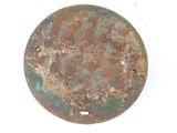 an old, rusted, round metal object on a white surface