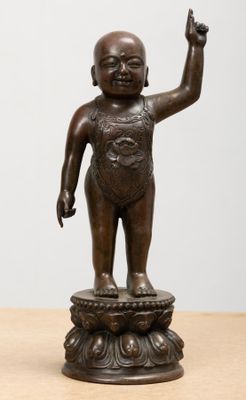 une photo d'une statue en bronze représentant un bébé sur un socle