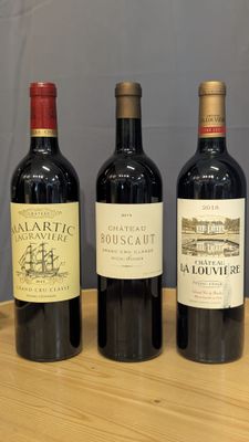 trois bouteilles de vin rouge sont alignées sur une table
