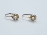 a pair of gold and pearl earrings on a white background