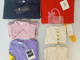 a group of t - shirts and a purse are sitting on a table