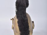 a black cat tail sticking out of a gold helmet