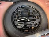 une voiture rose avec un pneu dans le coffre