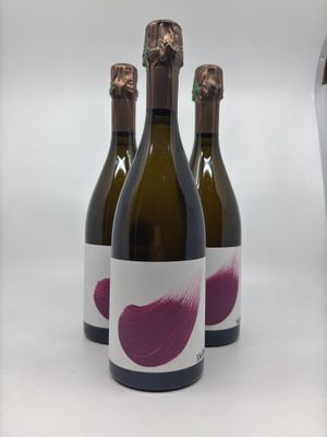 three bottles of wine are lined up on a white surface