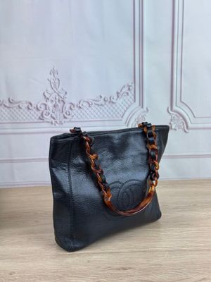 black leather handbag with tortoise chain handles