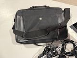 a black bag and a laptop on a white table