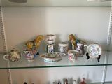 a glass shelf that has a lot of china on it