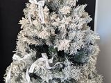 a small christmas tree with a white ribbon on it