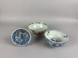 three blue and white bowls with designs on them sitting on a table