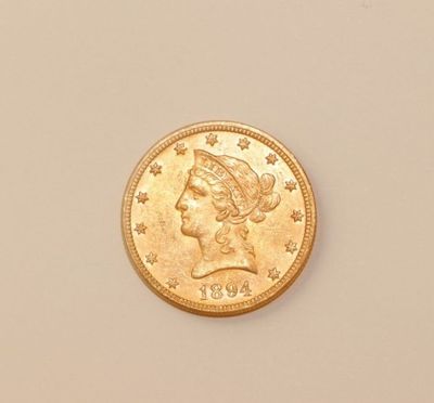a close up of a gold coin with a woman ' s head on it