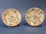 deux assiettes ornées de motifs floraux, posées sur un support
