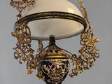 a gold and blue lamp hanging from a gold chain