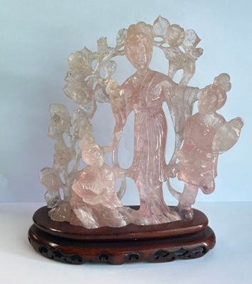statue représentant une femme tenant un enfant dans ses bras, posée sur un socle en bois