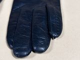 a pair of black leather gloves sitting on a table