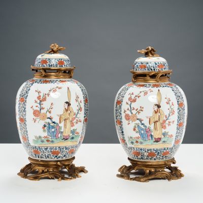 paire de vases chinois ornés de personnages, posés sur des socles et disposés sur une table