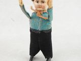 une petite figurine représentant un garçon tenant une fourchette et un couteau