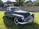 une voiture noire garée dans l'herbe